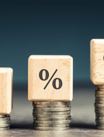 Three percentage signs on top of three coin stacks