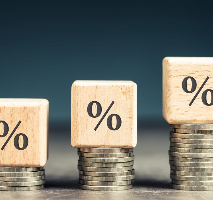 Three percentage signs on top of three coin stacks